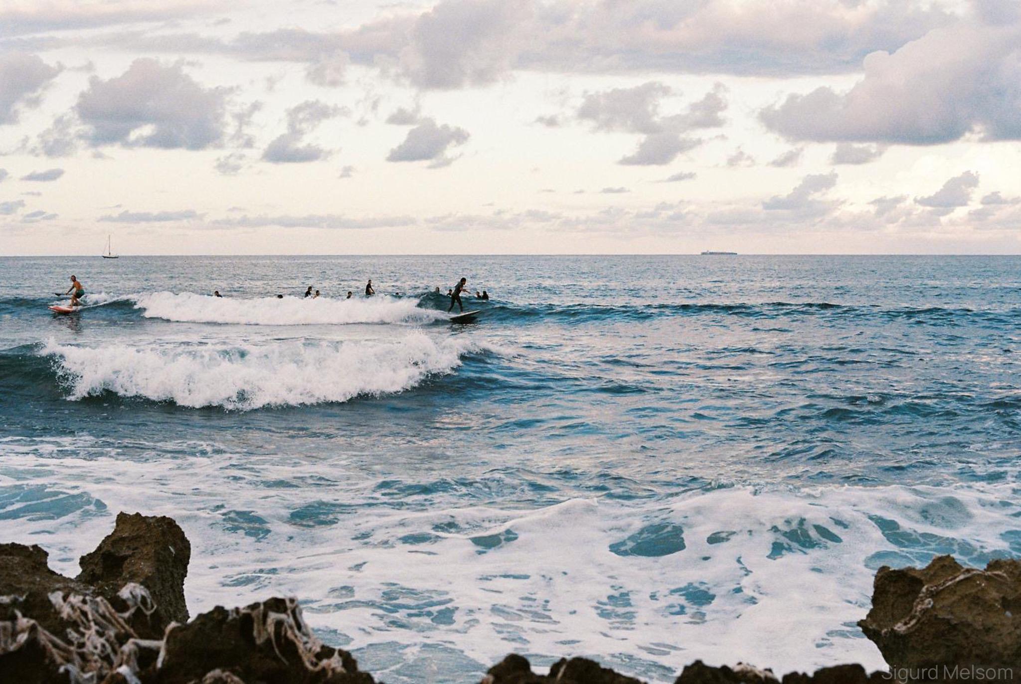 Surfere i bølgene ved en steinete kyst